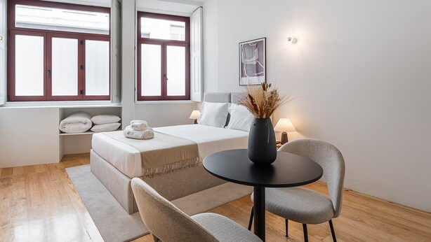 Une chambre à coucher moderne, comprenant un lit, des tables de chevet, un bureau et une chaise.