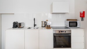 Une cuisine moderne équipée d’un évier en acier inoxydable, d’un four à micro-ondes, d’un grille-pain et d’un four encastré.