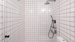Une salle de douche carrelée, équipée d’un pommeau de douche à main et d’un robinet mural.