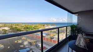 A balcony with a view of the ocean and a cityscape.
