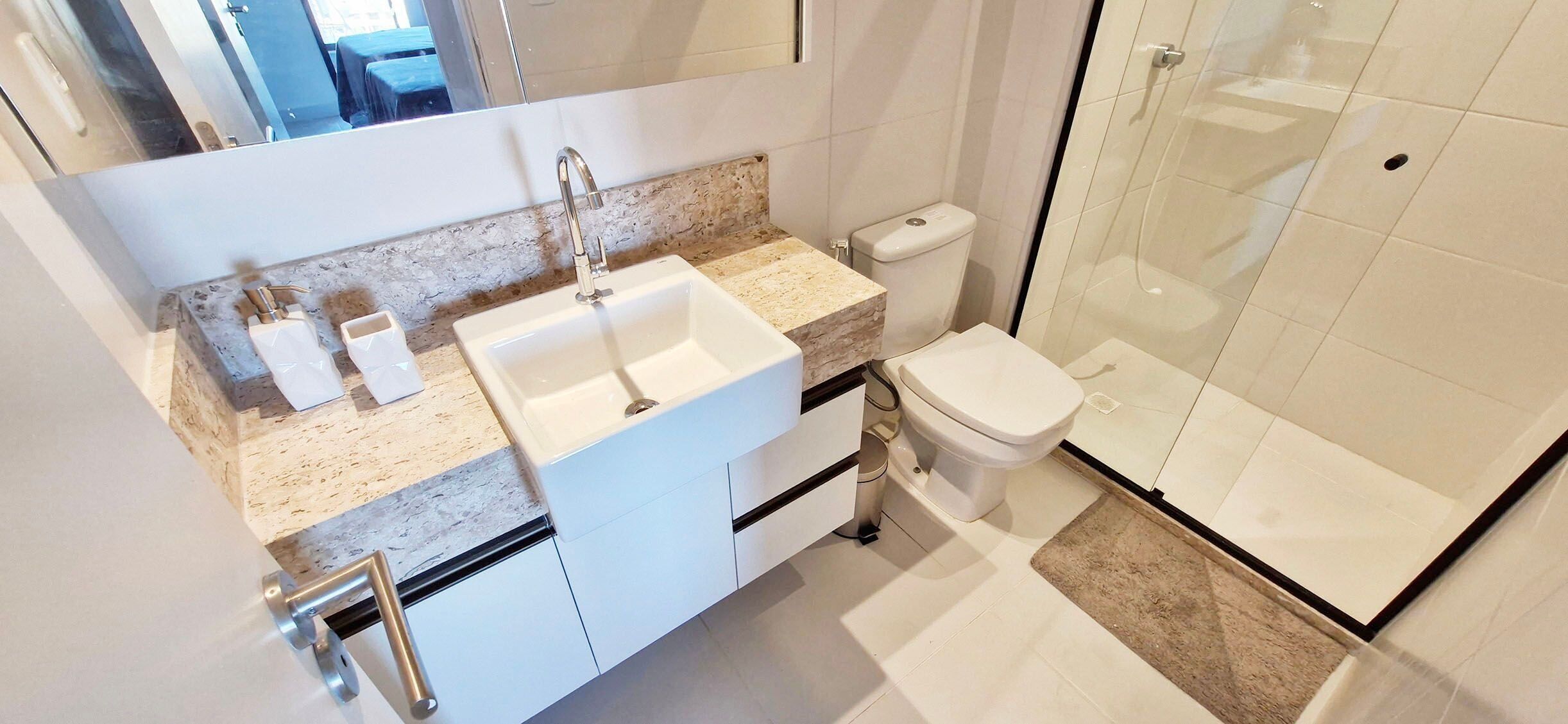 A modern bathroom with a sink, toilet, and glass-enclosed shower.