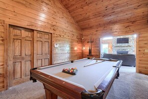A wooden interior with a pool table, a stone fireplace, and a bar area. - Timber View | Hocking Hills, Pool, Lodge, Pets (Rockbridge)