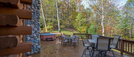A wooden deck with outdoor furniture and a stone wall.