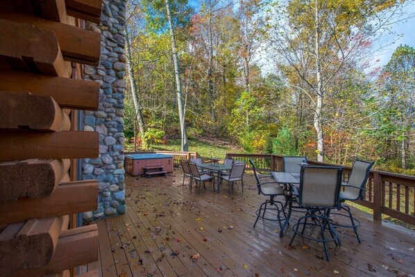 A wooden deck with outdoor furniture and a stone wall.