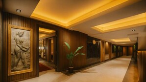 A hallway with a large framed sculpture, wooden paneling, and a potted plant. - Ramada Plaza by Wyndham Istanbul Sultanahmet (Istanbul)
