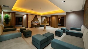 A modern lounge area with a central round table, cushioned seating, and a warm ceiling light. - Ramada Plaza by Wyndham Istanbul Sultanahmet (Istanbul)