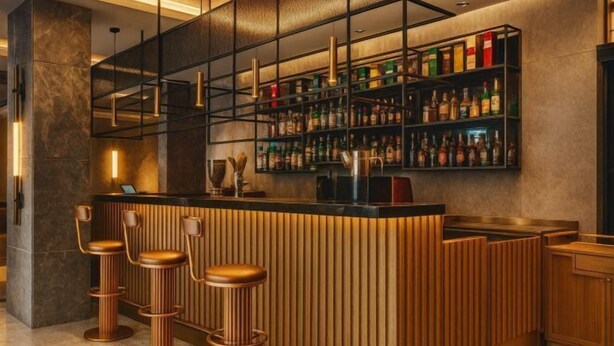 A bar area with a wooden counter, three stools, and shelves stocked with bottles. - Ramada Plaza by Wyndham Istanbul Sultanahmet (Istanbul)