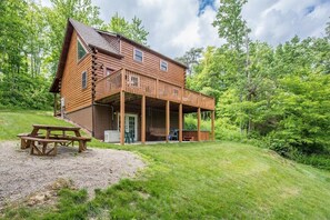 Une cabane en rondins avec une terrasse et une table de pique-nique.