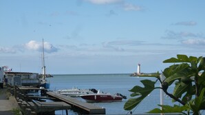 A marina with boats docked, a lighthouse in the distance, and a wooden pier. - Gîte La Parenthèse In a quiet Languedoc village, 8 minutes from Pézenas (Caux)