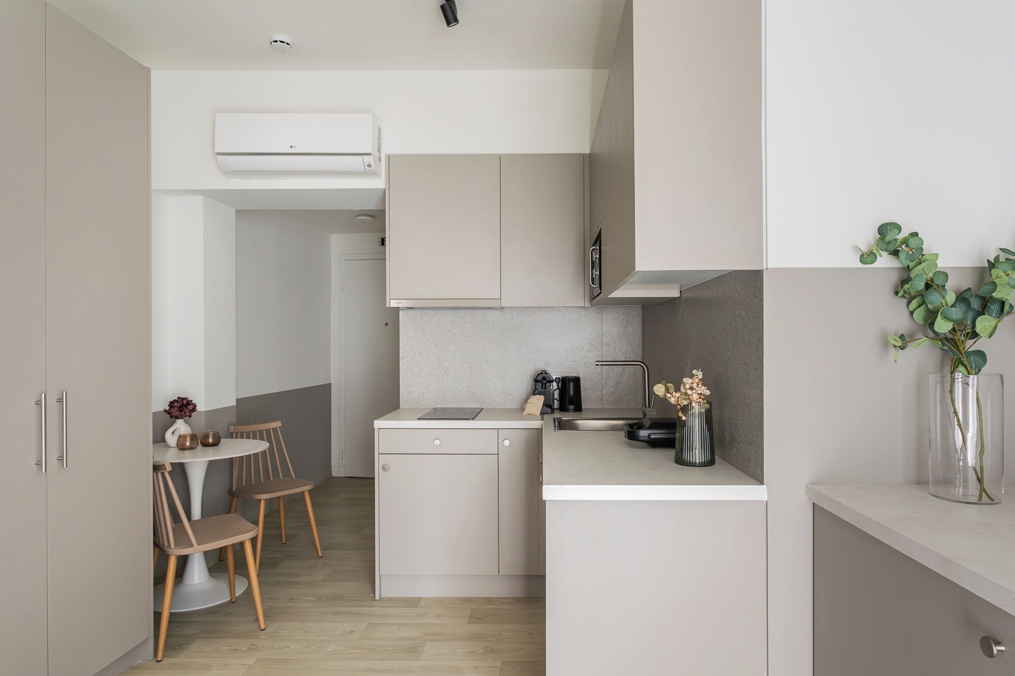 Una cucina compatta con zona pranzo, lavastoviglie e macchina del caffè.