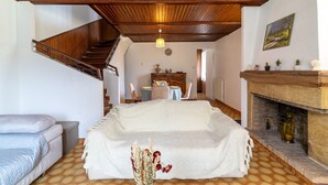 Una sala de estar acogedora con un sofá, una chimenea, un comedor y una escalera.