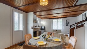 Un comedor con una mesa redonda, sillas y una chimenea.
