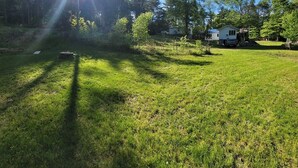 A grassy outdoor area with a house in the background.
