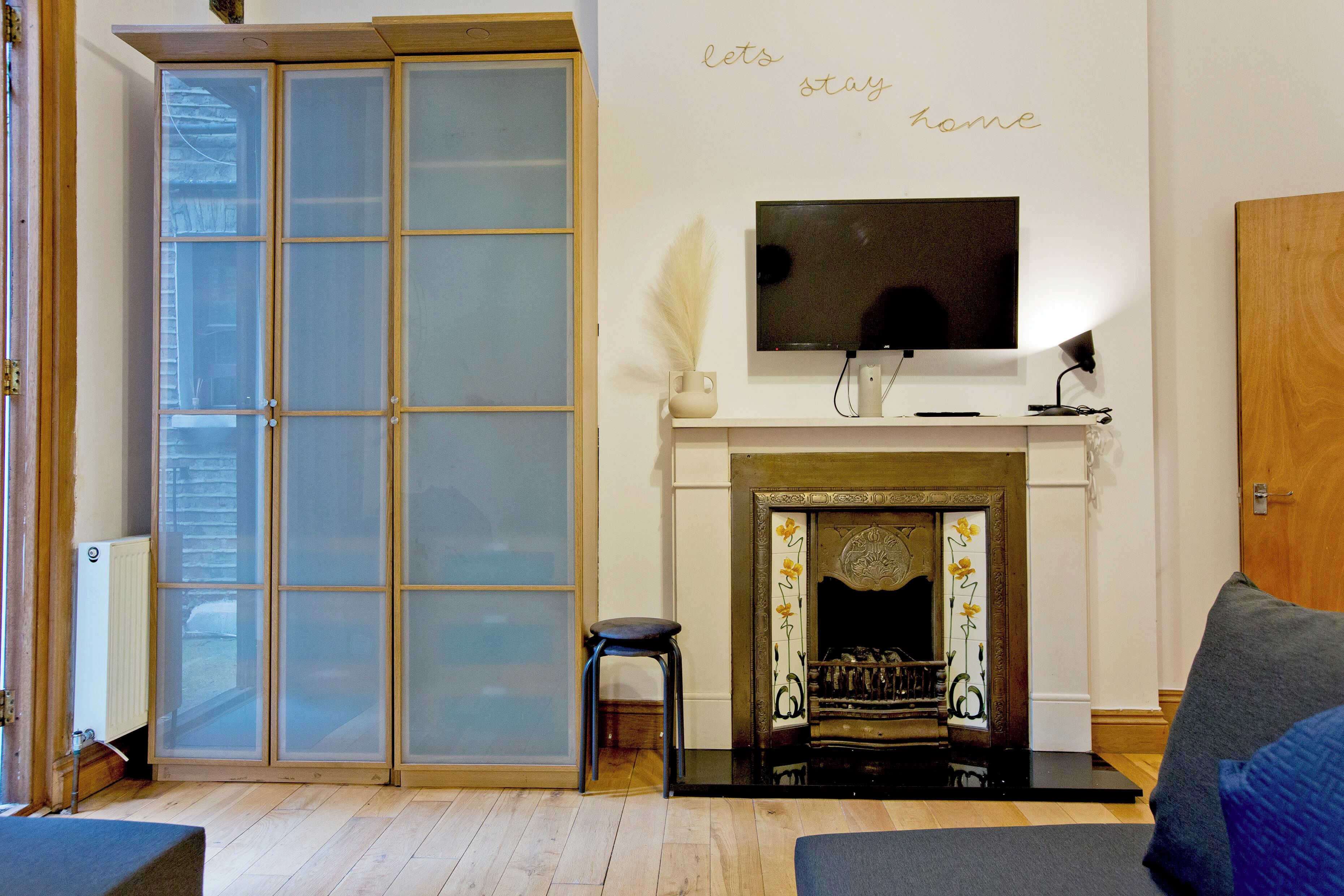 Una sala de estar con chimenea, televisor y puerta corrediza de vidrio.