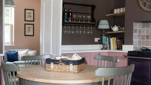 A dining area with a round table, four chairs, a chandelier, a bookshelf, and a clock on the wall. - Pretty Riverside Cottage, Petworth
Two Bedrooms, Sleeps 3. Dogs Welcome (Petworth)