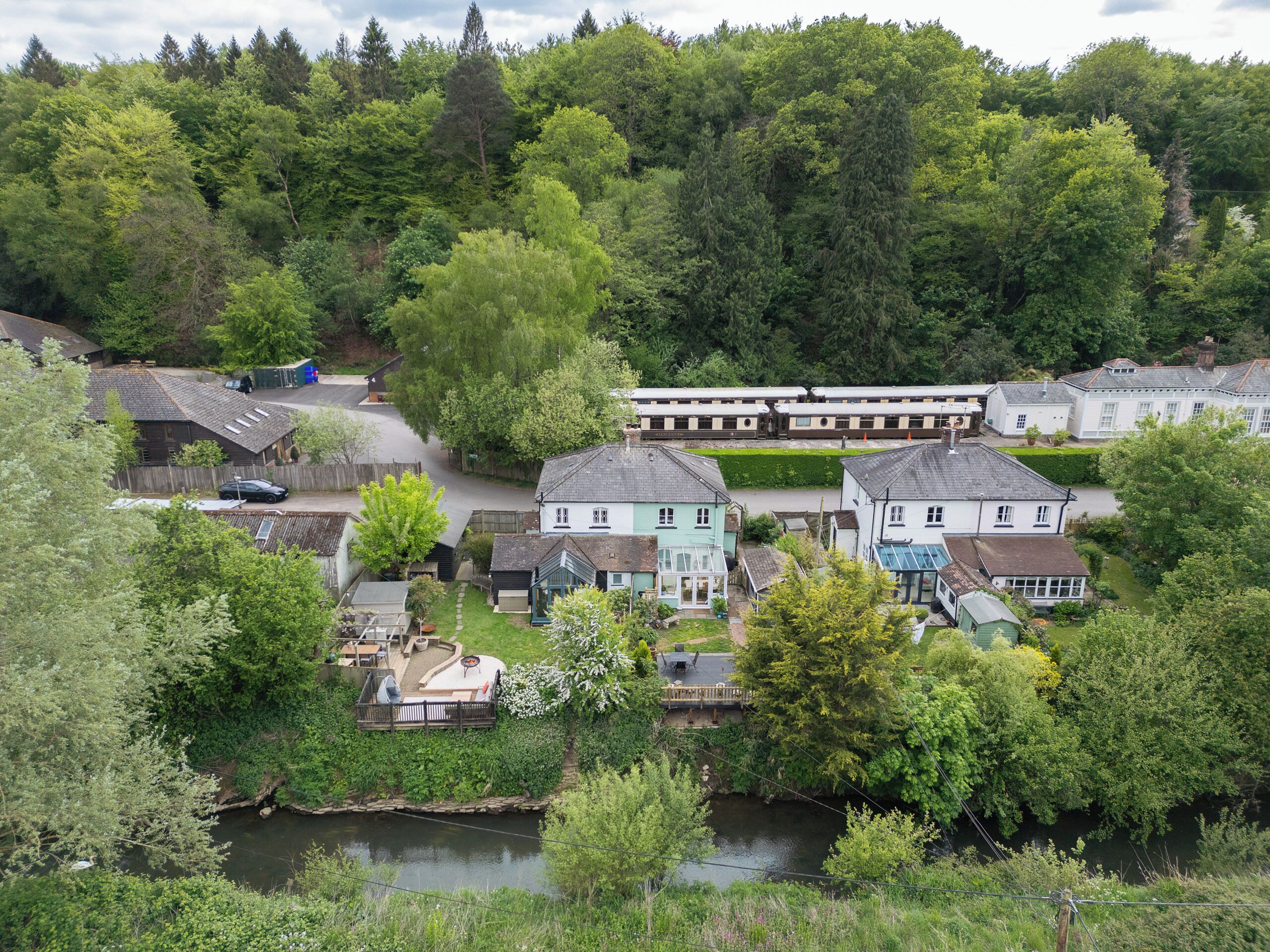 Een rivierdorp met traditionele huizen, een klein bruggetje en een treinstation.