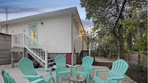A house with a porch, outdoor seating area, and a staircase leading to a door. - Charming 3BR in St. Augustine - Walk to Downtown, Near Beach, Wifi & A/C! (St. Augustine)