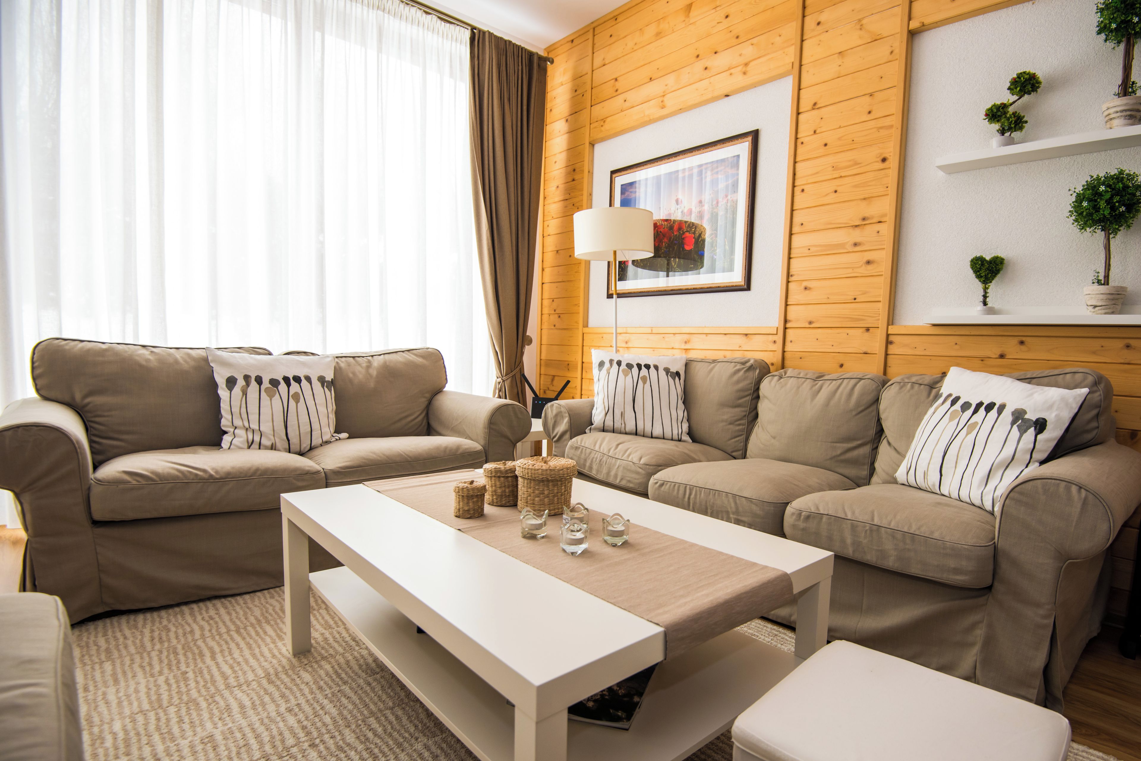Ein modernes Wohnzimmer mit zwei Sofas, einem Couchtisch und einer Lampe.