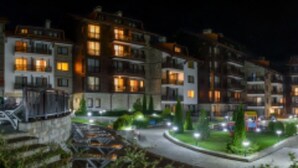 Un hotel de diverses plantes amb balcons, un pati central i façana ben il·luminada.
