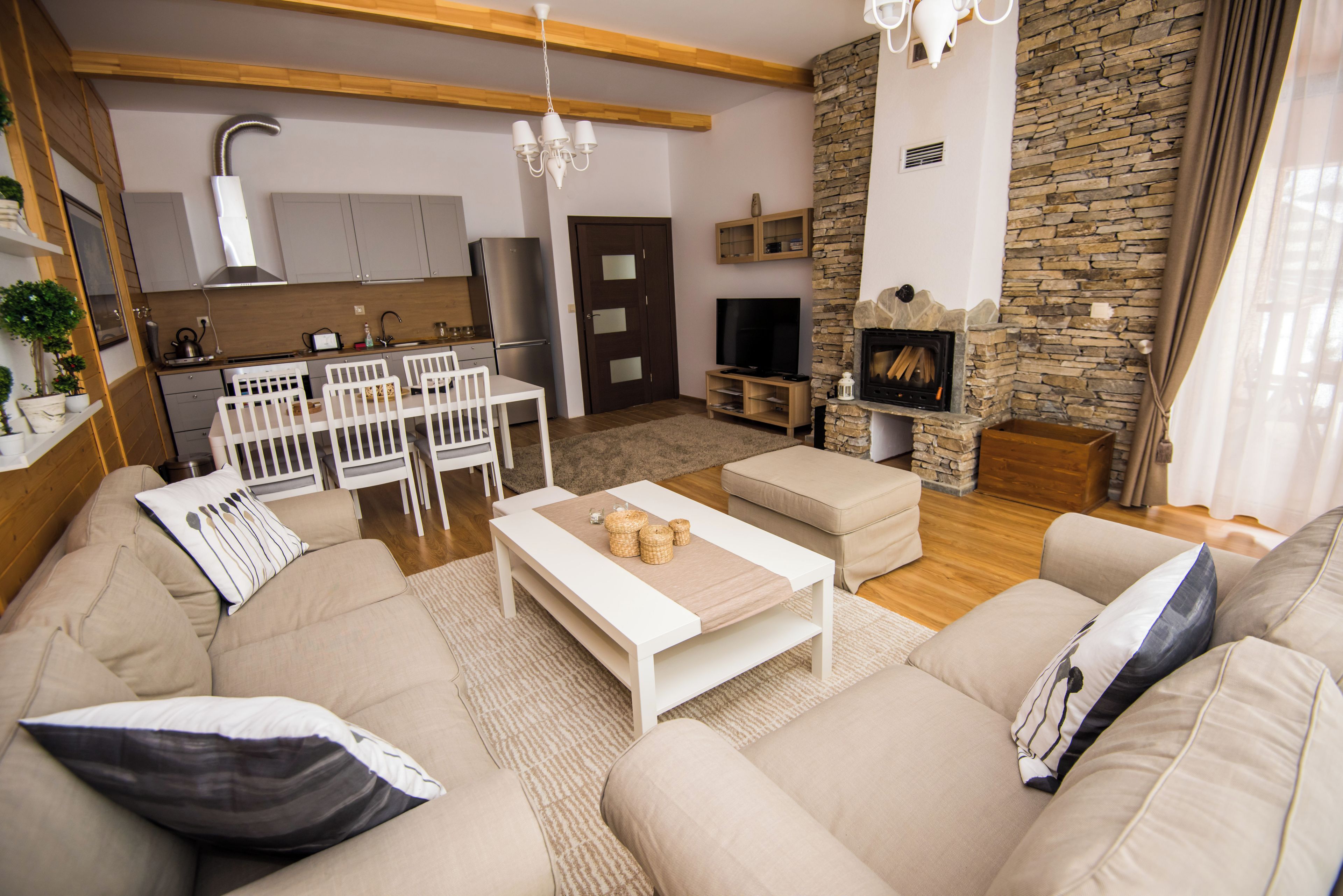 A modern living room with a sofa, coffee table, and a stone fireplace.