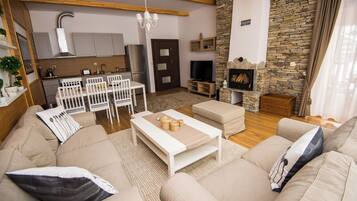 A modern living room with a sofa, coffee table, and a stone fireplace.