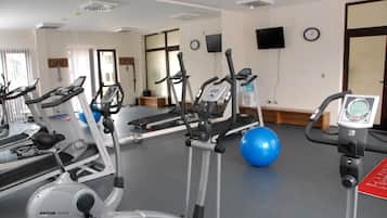A gym with stationary bikes, treadmills, and exercise balls.