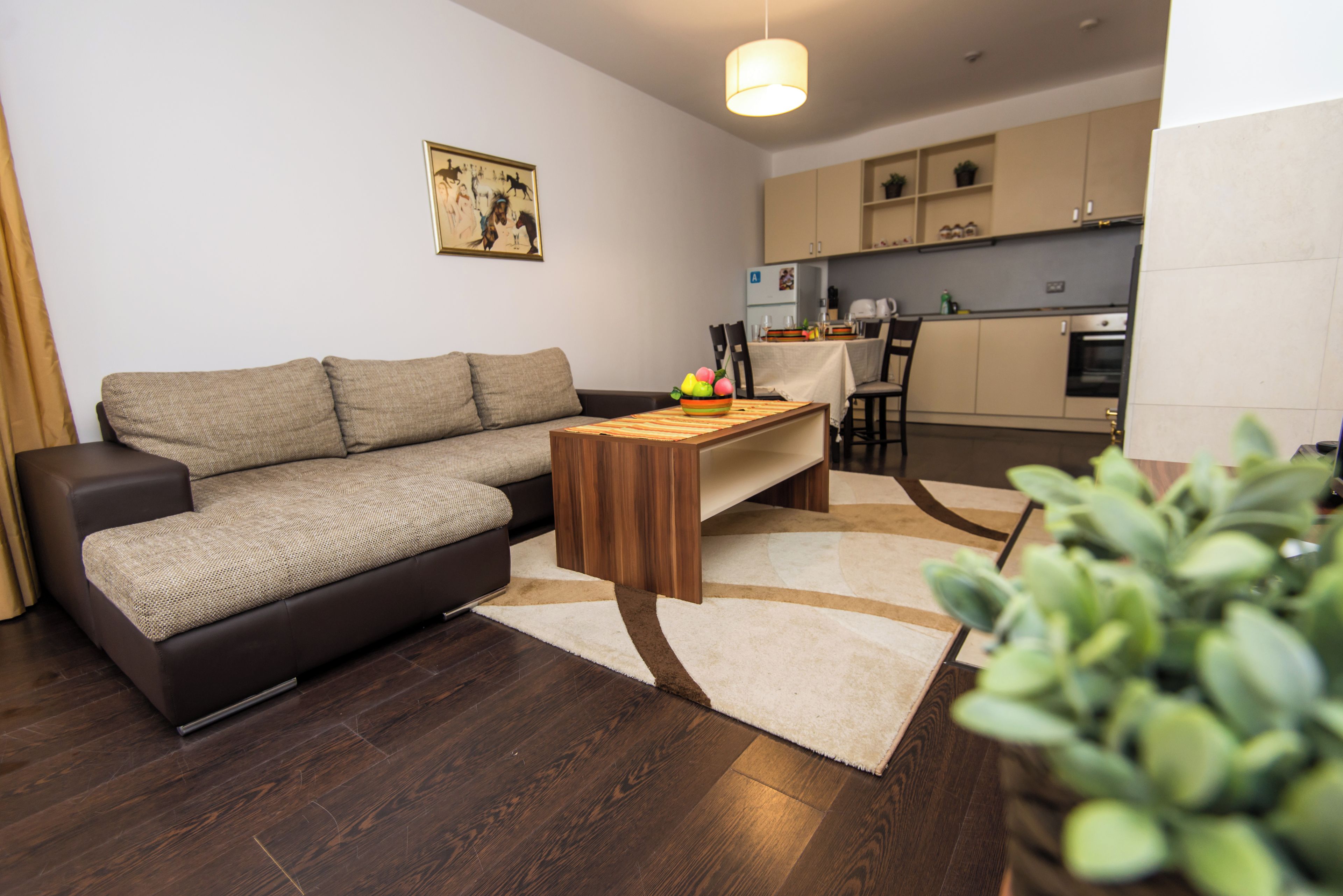 A modern living room with a sofa, a coffee table, and a dining area with chairs.