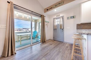 A room with a sliding glass door leading to an outdoor area with chairs and a table.