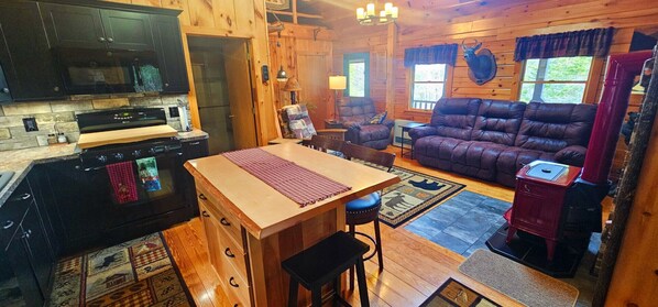 Un intérieur de chalet chaleureux comprenant une cuisine, un coin repas et un salon.