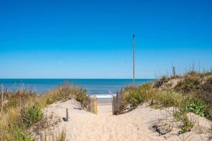 A sandy beach path leading to the ocean with a wooden gate, surrounded by vegetation. - 2Min Walk to Beach - Pool, Hot Tub, Ocean Views (Corolla)