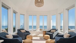 A room with large windows, a ceiling light, and a view of the ocean. - Oceanfront, Pool & Hot Tub, Game Room, EV Charger (Corolla)