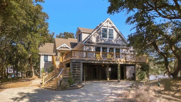A large, two-story house with a balcony and a covered porch.