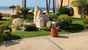 Un resort con piscina, palmeras y vista al océano.