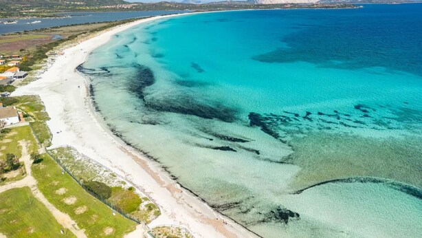 An aerial view of a coastal area with a sandy beach, clear turquoise waters, and distant mountains. - Elegant Villa With Private Pool in San Teodoro (San Teodoro)