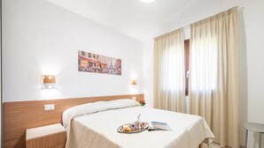 A hotel room with a bed, bedside table, and a painting on the wall. - Elegant Villa With Private Pool in San Teodoro (San Teodoro)
