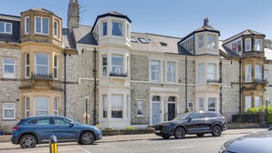 A row of traditional terraced houses with bay windows and a central entrance. - Heaton House Apartment - North East Escapes (Tynemouth)