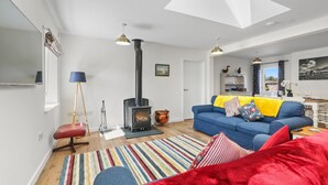 A living room with a fireplace, a sofa, a coffee table, and a striped rug.