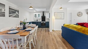 A modern apartment with a dining area, kitchen, and living room.
