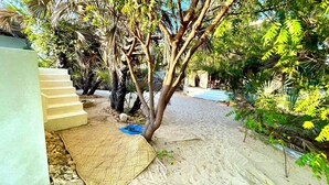A sandy courtyard with a staircase leading to a building, surrounded by lush greenery and trees. - Dreamy Beachfront house with pool secluded miles beach Che Shale Malindi Kenya (Che shale Bay, Malindi)