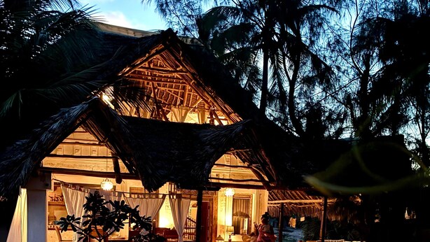 A beachfront resort with a thatched-roof structure, outdoor seating, and a sandy beach. - Dreamy Beachfront house with pool secluded miles beach Che Shale Malindi Kenya (Che shale Bay, Malindi)