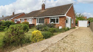A row of brick houses with a gravel driveway and a garden in front. - Little Lodge (King's Lynn)