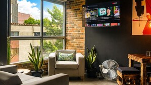 A modern living room with a sofa, armchair, and potted plants. - Stylish Laureles Loft in Medellin (Medellín)