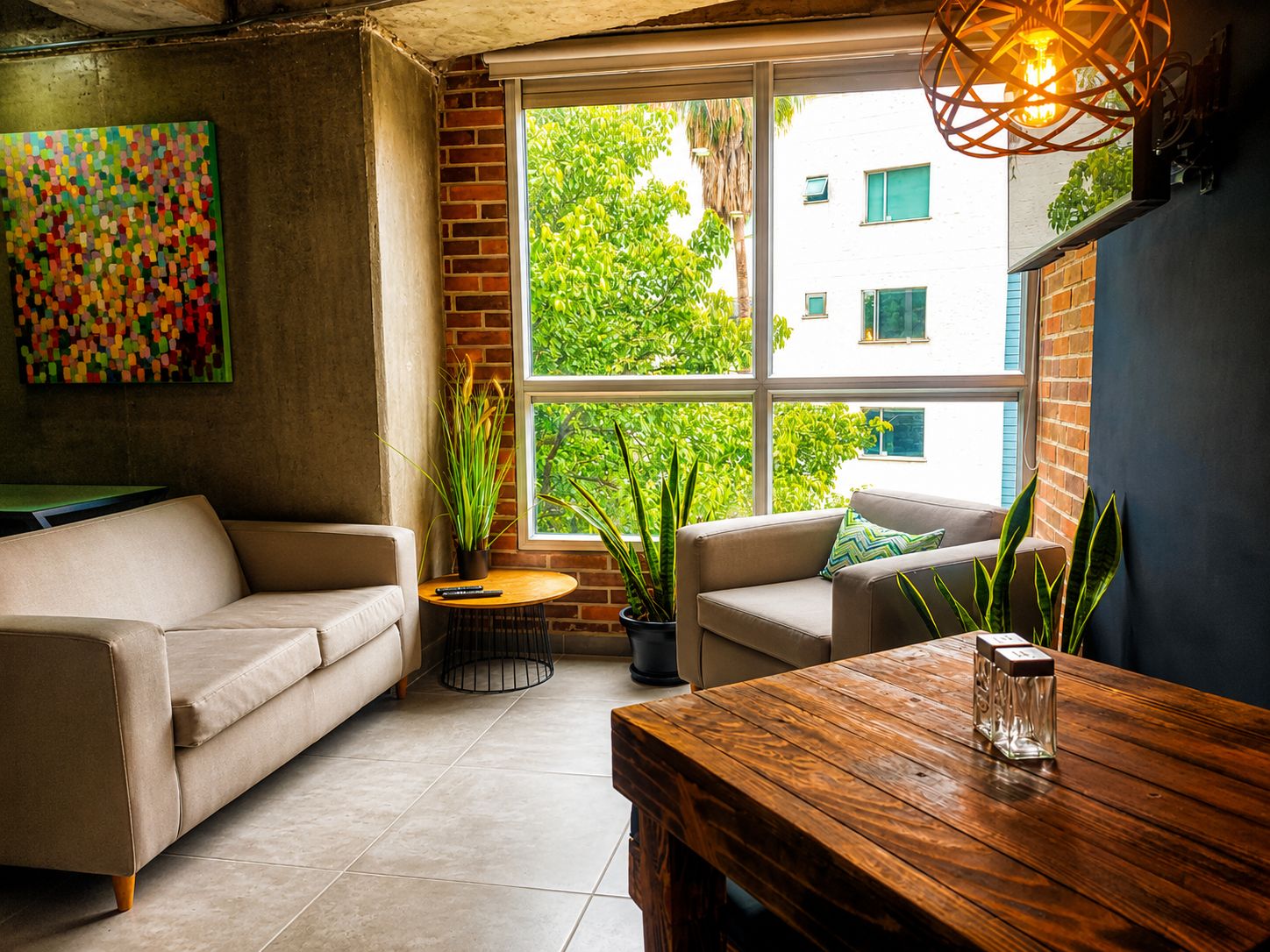 Ein gemütliches Wohnzimmer mit einer Couch, einem Holztisch und einer Zimmerpflanze.
