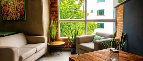Una sala de estar acogedora con un sofá, una mesa de centro de madera y una planta en maceta.