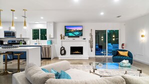 A modern living room with a fireplace, a television, and a sofa.