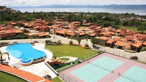 A resort with a swimming pool, tennis courts, and a view of the sea. - ANANA El Dorado 203 (Ajijic)
