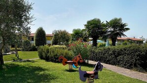 A garden with sculptures of animals and a paved walkway. - Residence Ducale three-room apartment E16 C6*+ for 5 people (Bibione)