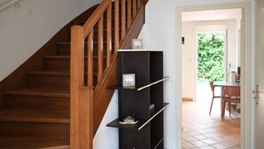 A wooden staircase with a black shelf unit against the wall.