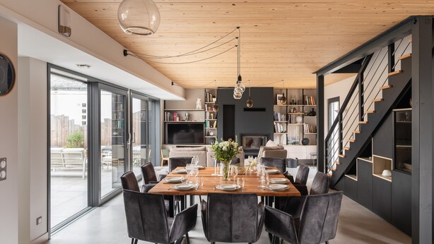 A modern dining area with a wooden table set for six, surrounded by black chairs. - Villa Ker Jade - vue sur la mer (Lancieux)