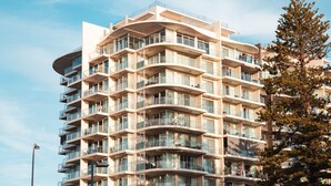 Un hôtel à plusieurs étages doté de balcons, de grandes fenêtres et d’une architecture moderne.